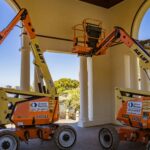 Two Mobile elevated working platforms, ready for use at a construction site